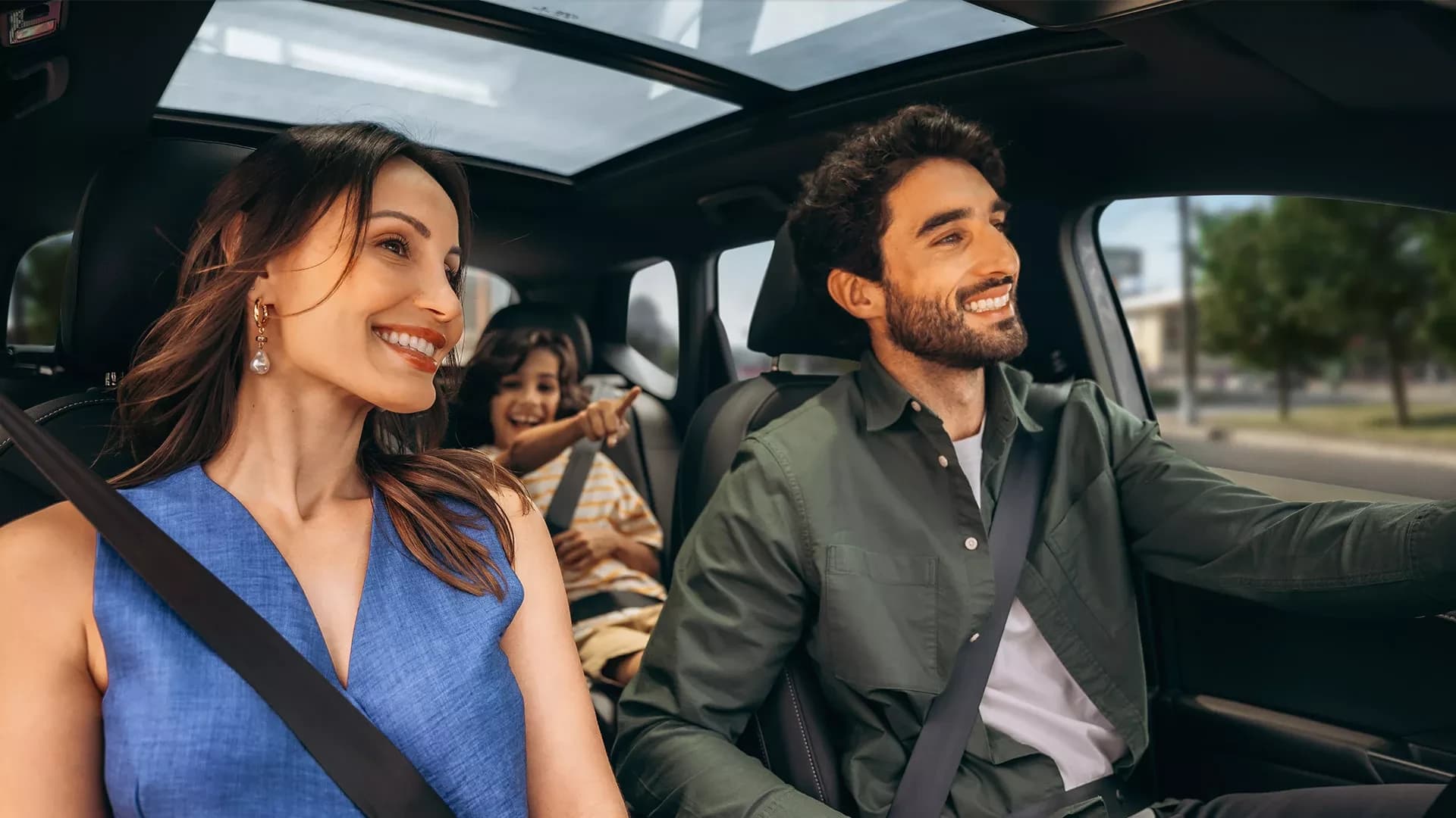 Família sorrindo dentro de um Volkswagen com teto panorâmico